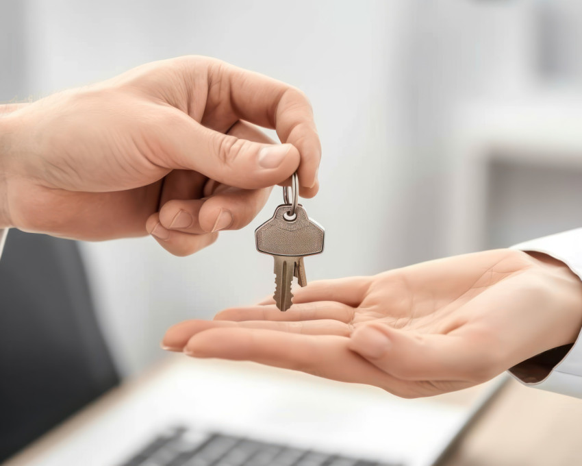 Realtor hands over keys to new apartment in mortgage purchase sealing the deal with the buyer in a real estate transaction Realtor hands over keys to new apartment in mortgage purchase sealing the deal with the buyer in a real estate transaction