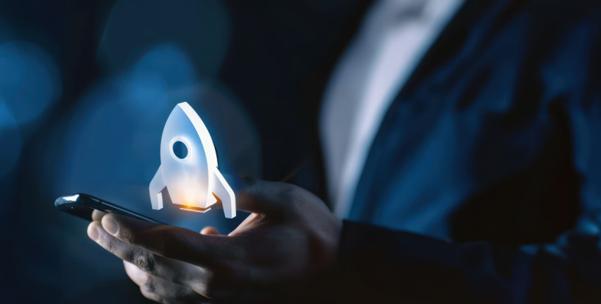 Businessman holding phone with rocket icon on the screen symbolizing startup launch Businessman holding phone with rocket icon on the screen symbolizing startup launch
