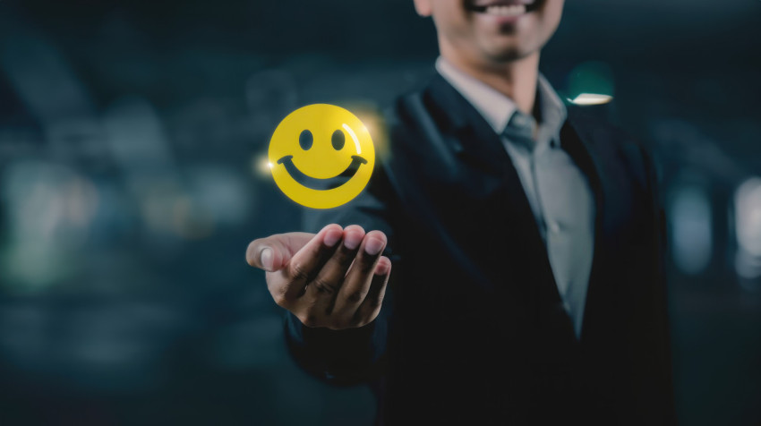 Businessman holding yellow smiley face icon with stars illustrating positive feedback concept in business Businessman holding yellow smiley face icon with stars illustrating positive feedback concept in business, customer satisfaction, business success