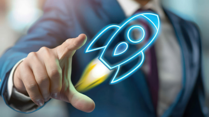 Businessman interacting with holographic rocket icon representing business startup Businessman interacting with holographic rocket icon representing business startup