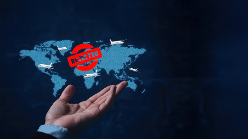 Hand holding a world map with airplanes flying and visa reject icons symbolizing global travel challenges Hand holding a world map with airplanes flying and visa reject icons symbolizing global travel challenges