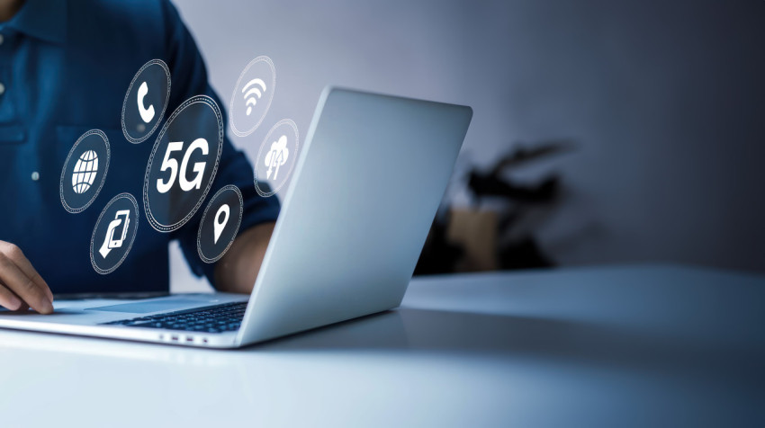 A man hand using a laptop with a 5G icon on the screen