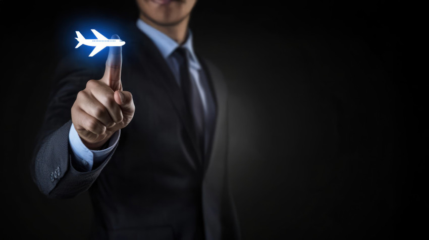 Businessman touching airplane icon on virtual screen over black background Businessman touching airplane icon on virtual screen over black background
