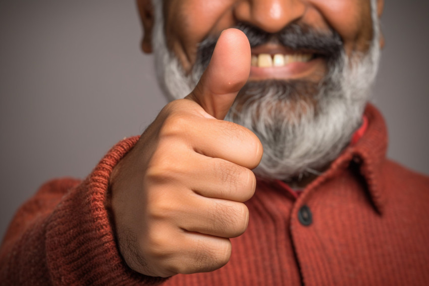 Happy Indian man with key and thumbs up Happy Indian man with key and thumbs up