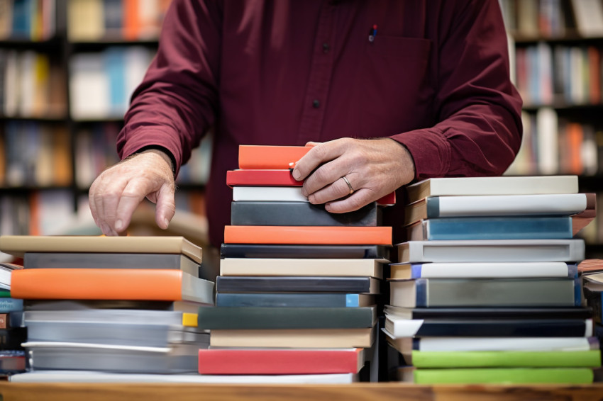 Bookstore owner with book and laptop Bookstore owner with book and laptop