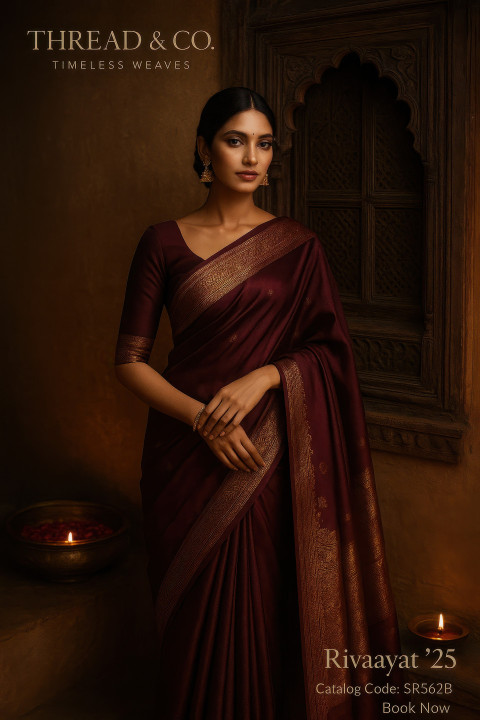 Woman in wine Banarasi silk saree stands near antique jharokha window in haveli with brass lamp and rose petals Woman in wine Banarasi silk saree stands near antique jharokha window in haveli with brass lamp and rose petals