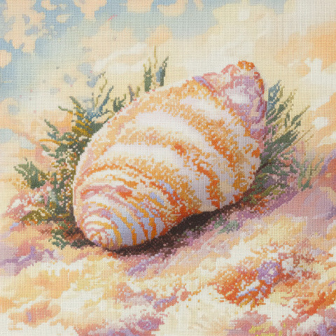 A cross stitched seashell resting on soft sand A cross stitched seashell resting on soft sand